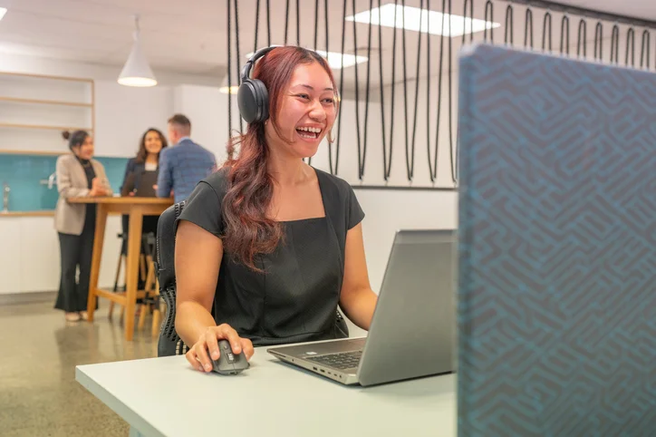Woman wearing headphones using computer