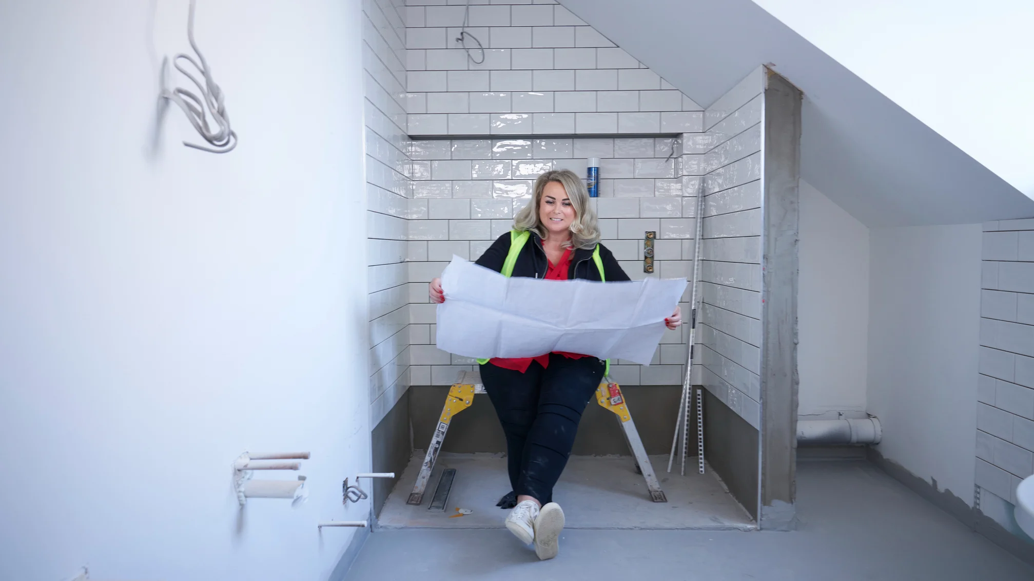 Lady looking at plans in bathroom renovation