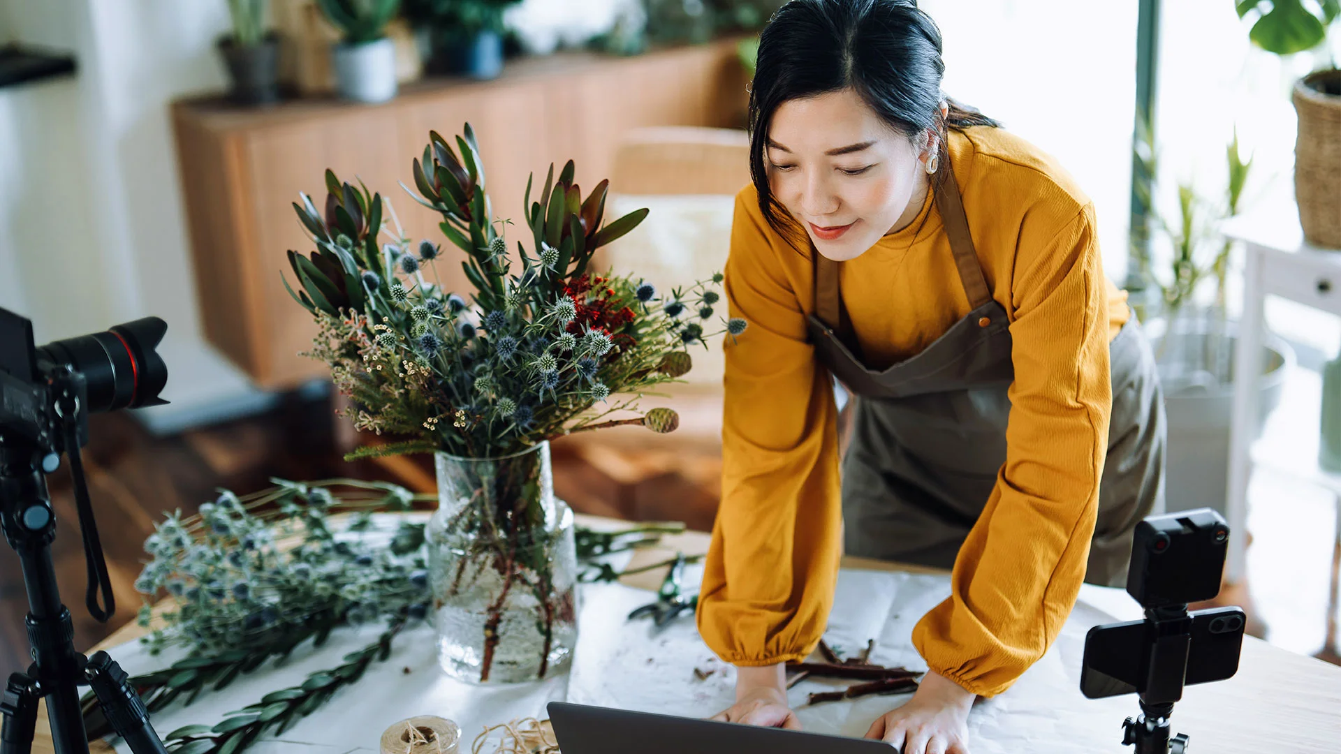 Woman arranging flowers at home in New Zealand to earn money through her side hustle business.