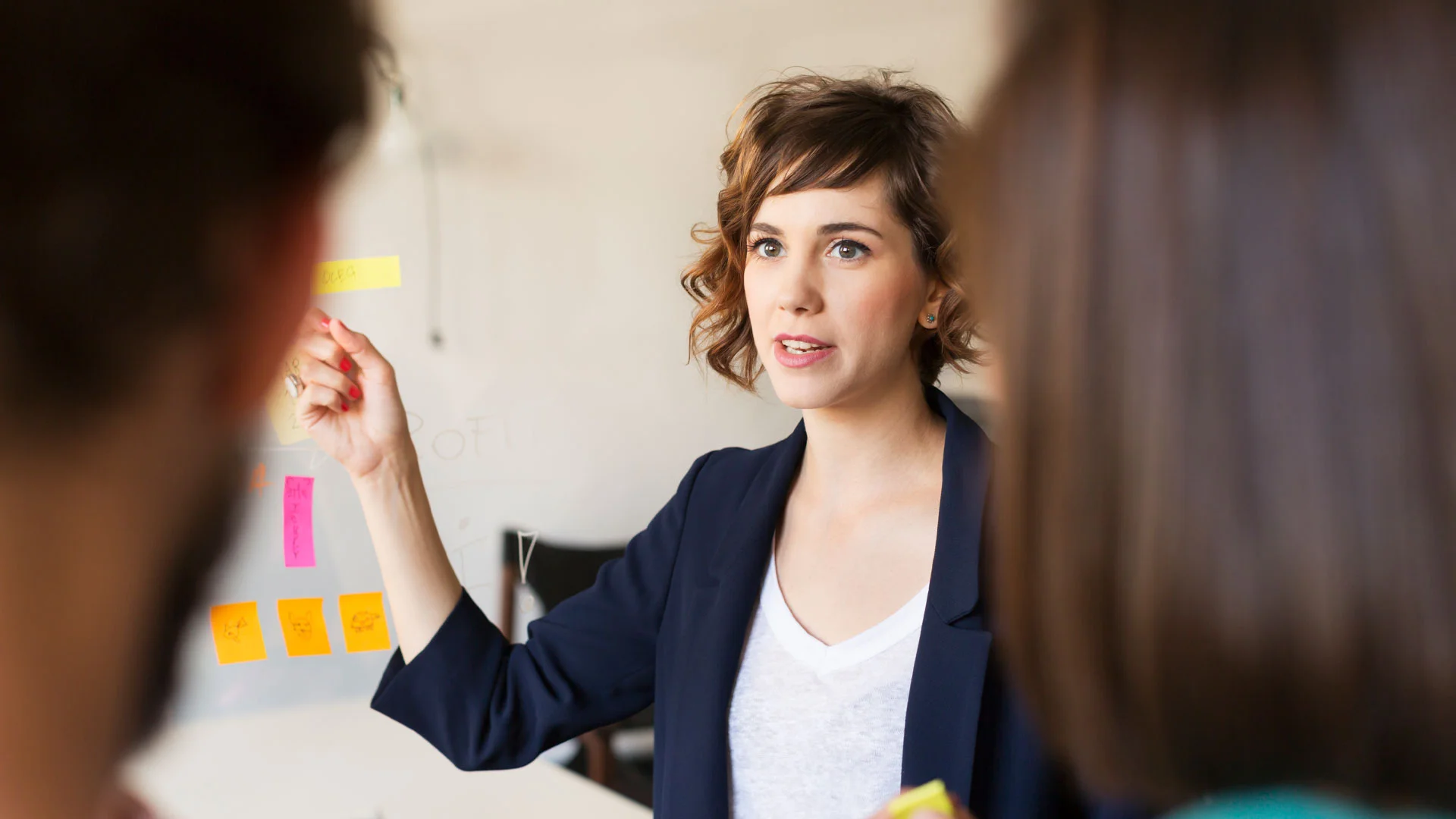 Young professional giving a presentation to her colleagues.
