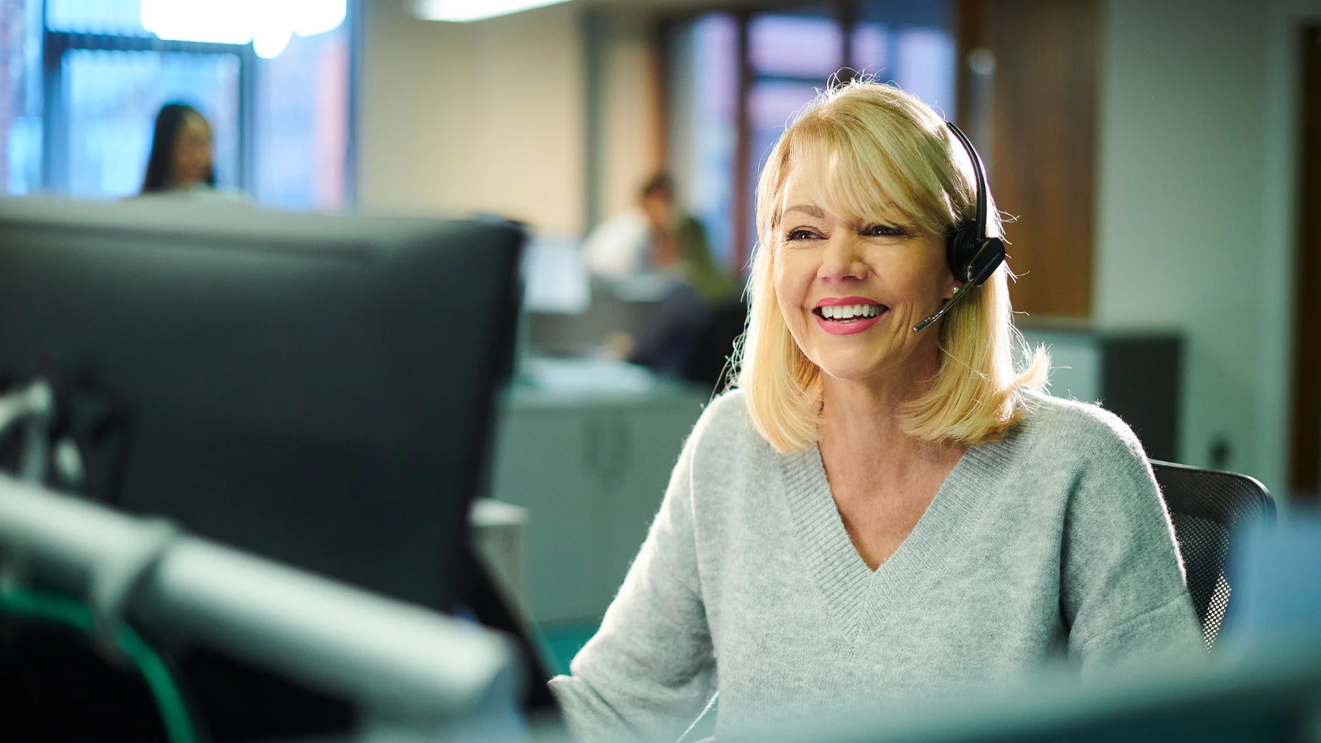 Female customer service representative speaking into a headset.