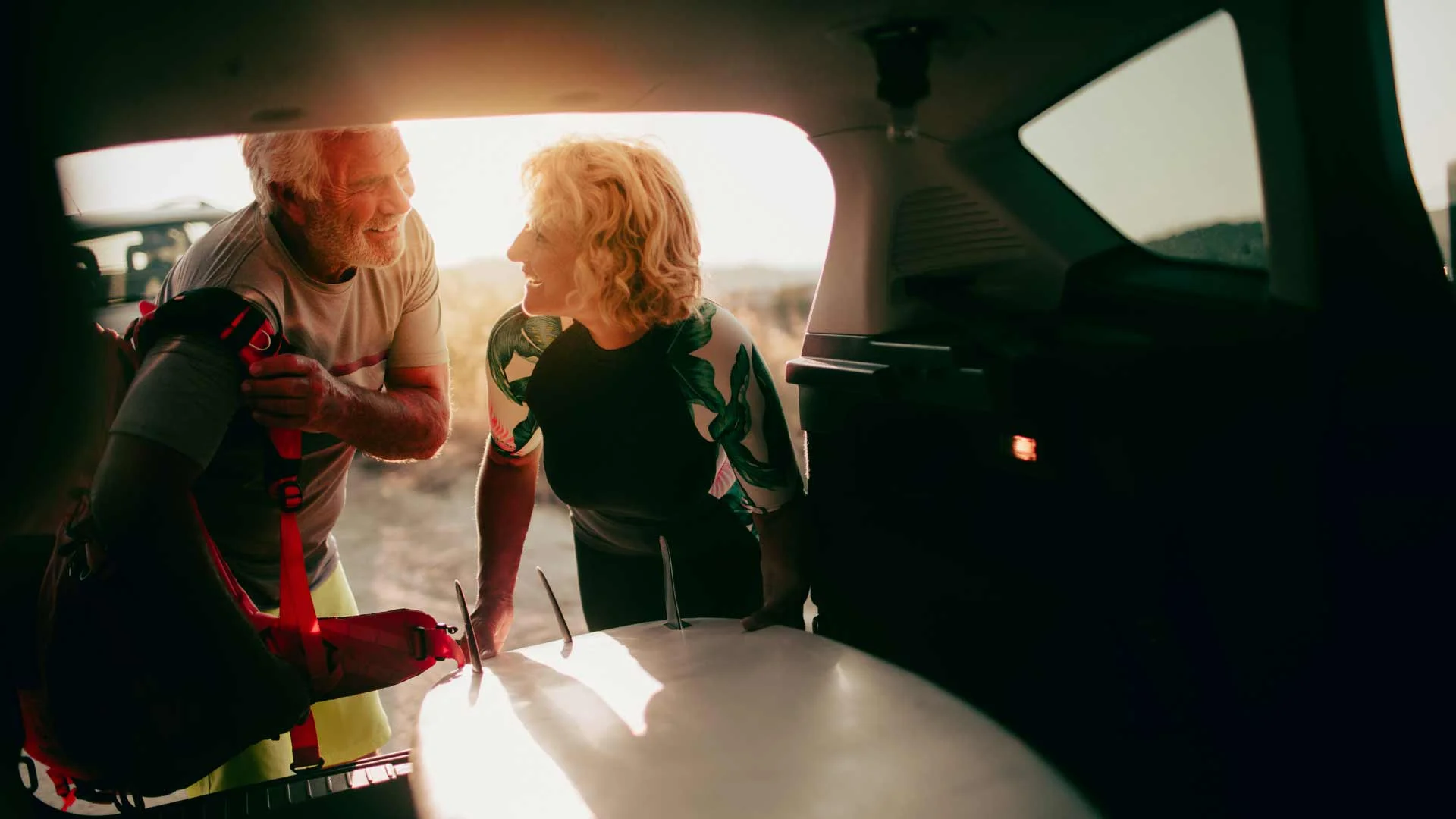 Couple loading into back of small car