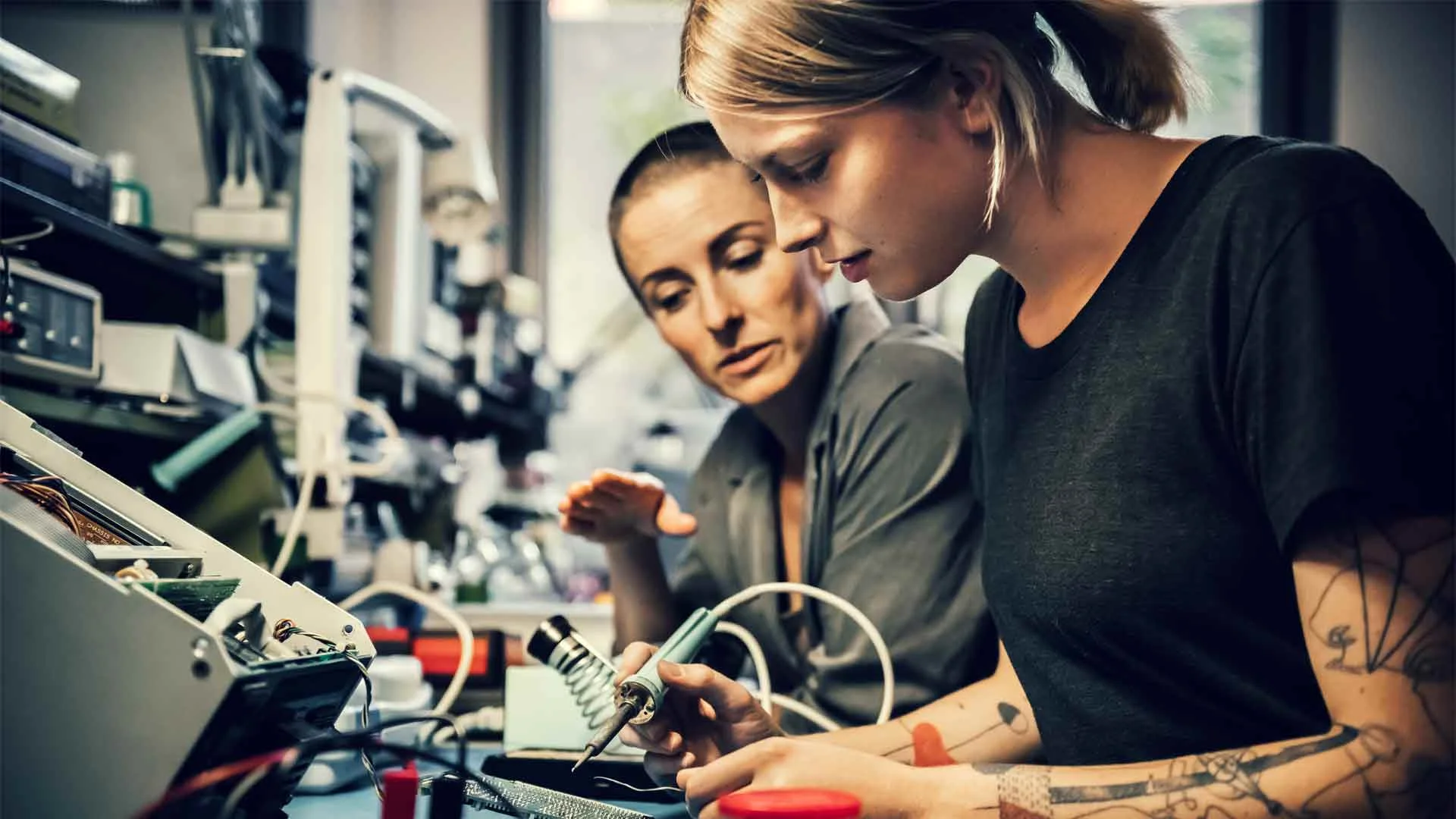 Manager training a young member of staff in her first job.