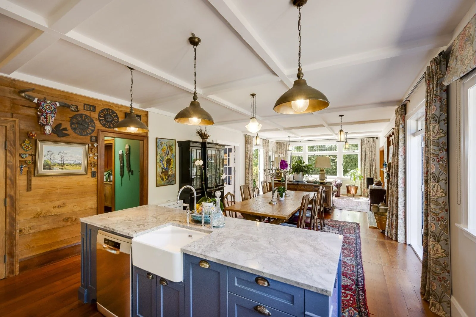 Vintage country kitchen filled with charm, featuring patterned wallpaper, wooden cabinets, and classic farmhouse touches. 