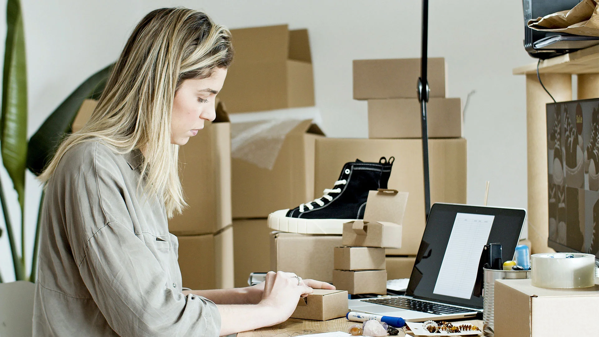 Woman boxing up items she has sold on Trade Me.