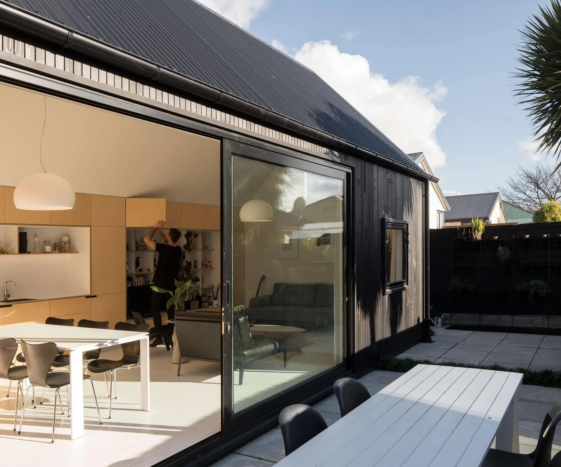 A sleek kitchen featuring a single continuous unit with a large glass door spanning its length, providing a modern and open feel.