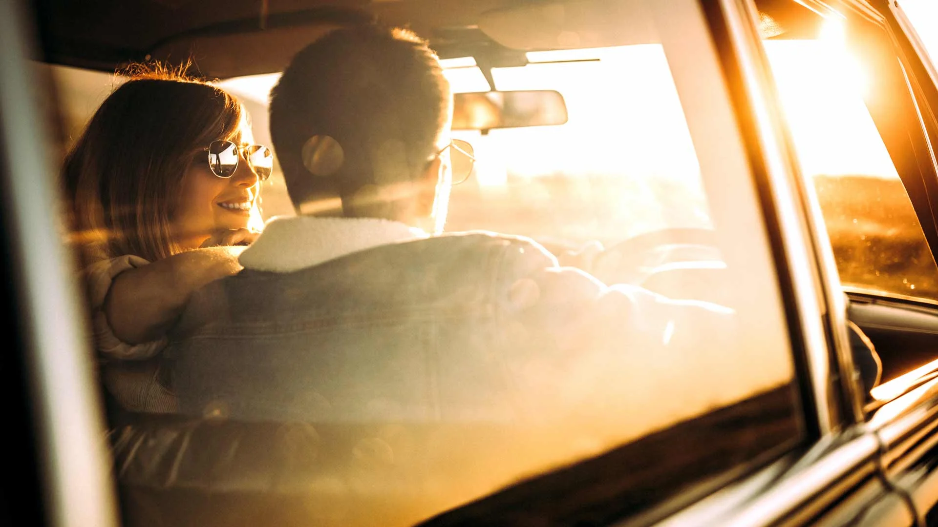 Young woman and man in front of car