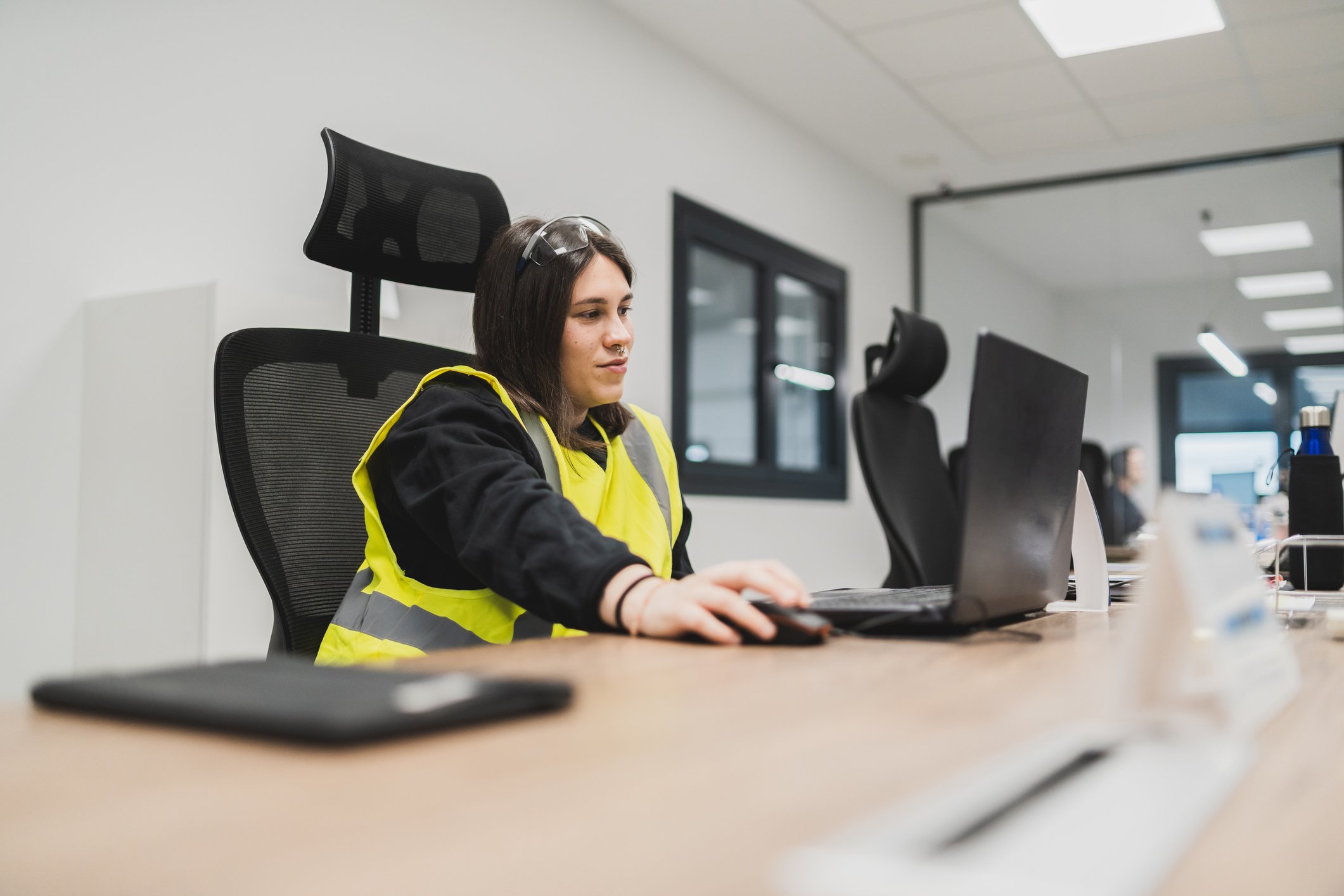 Woman sitting at desk in an office looking at her computer