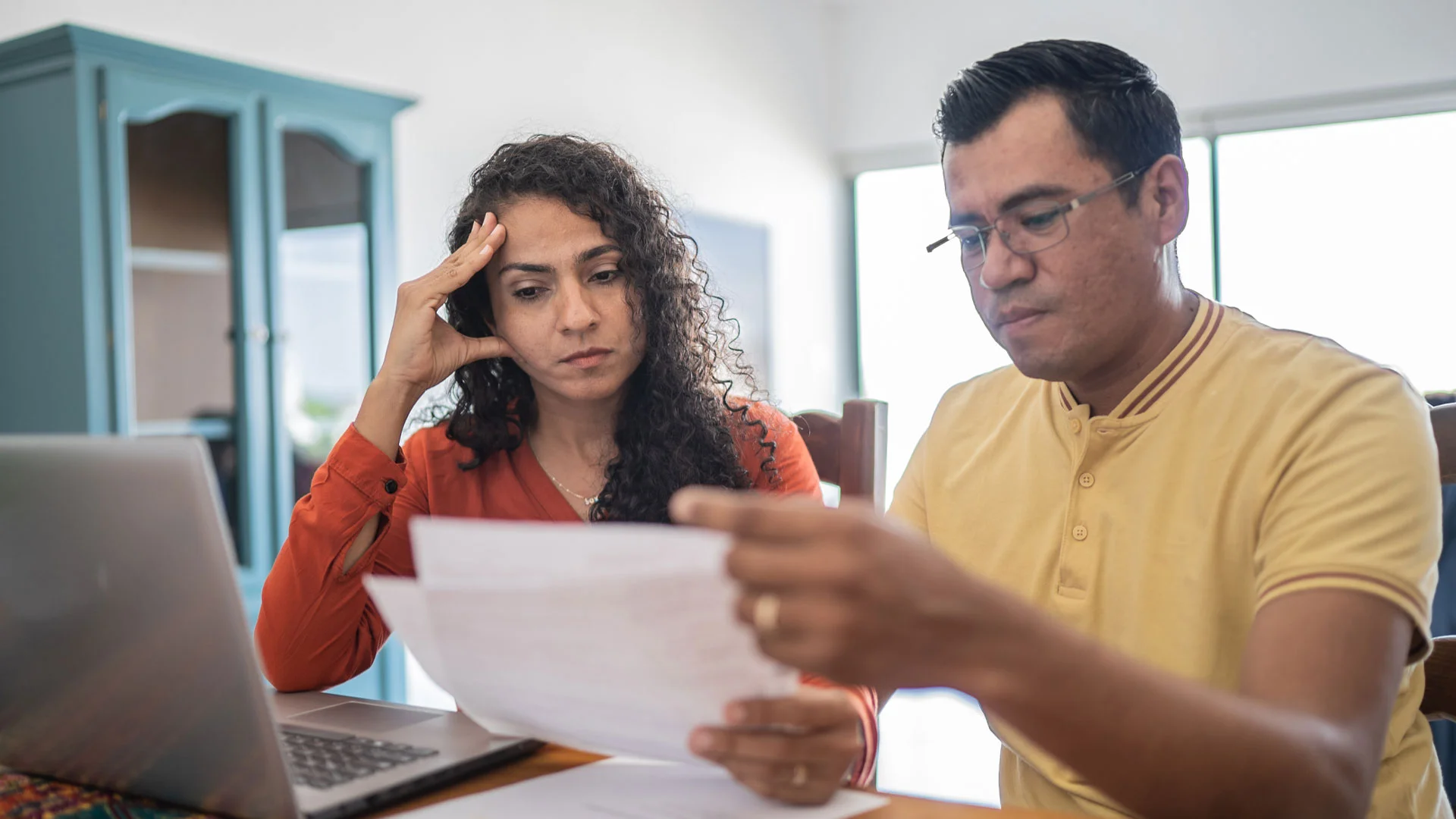 A stressed couple reading the sale and purchase agreement for a home purchase in New Zealand.