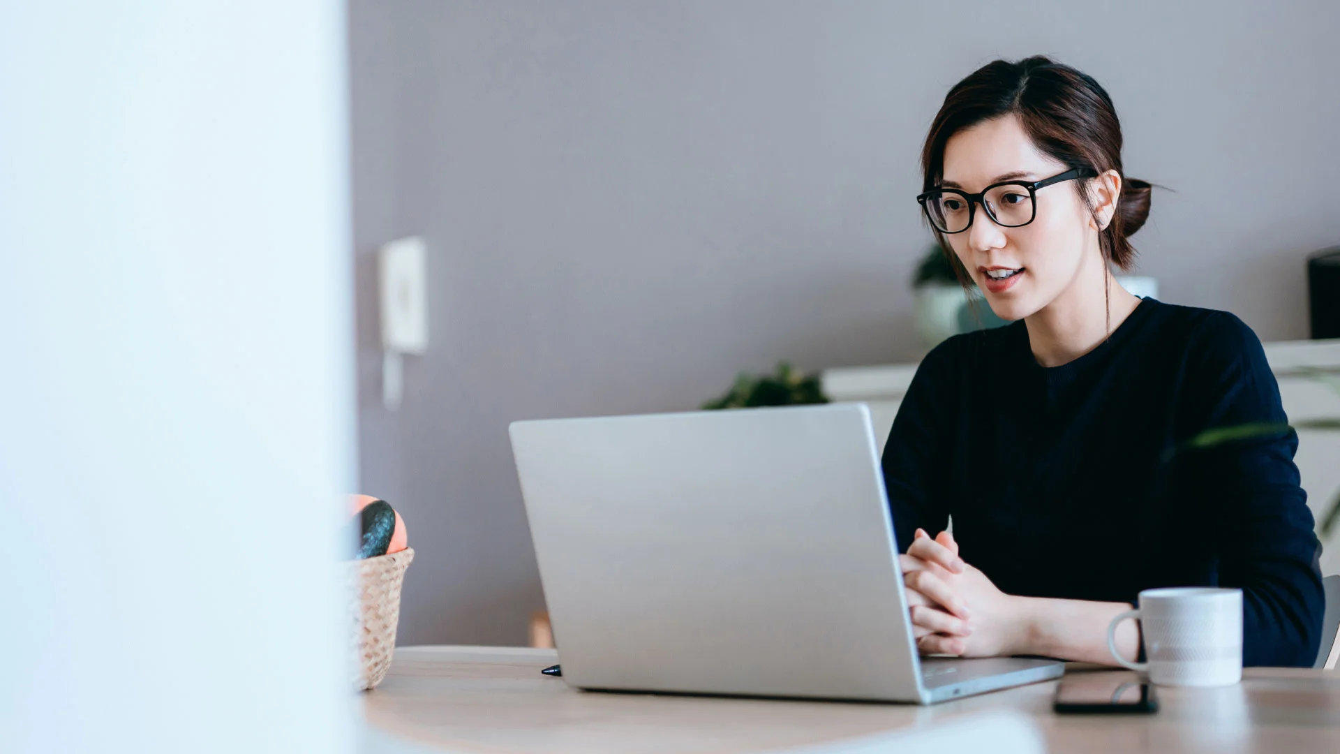 Young woman reading a Trade Me Jobs advert on her laptop.