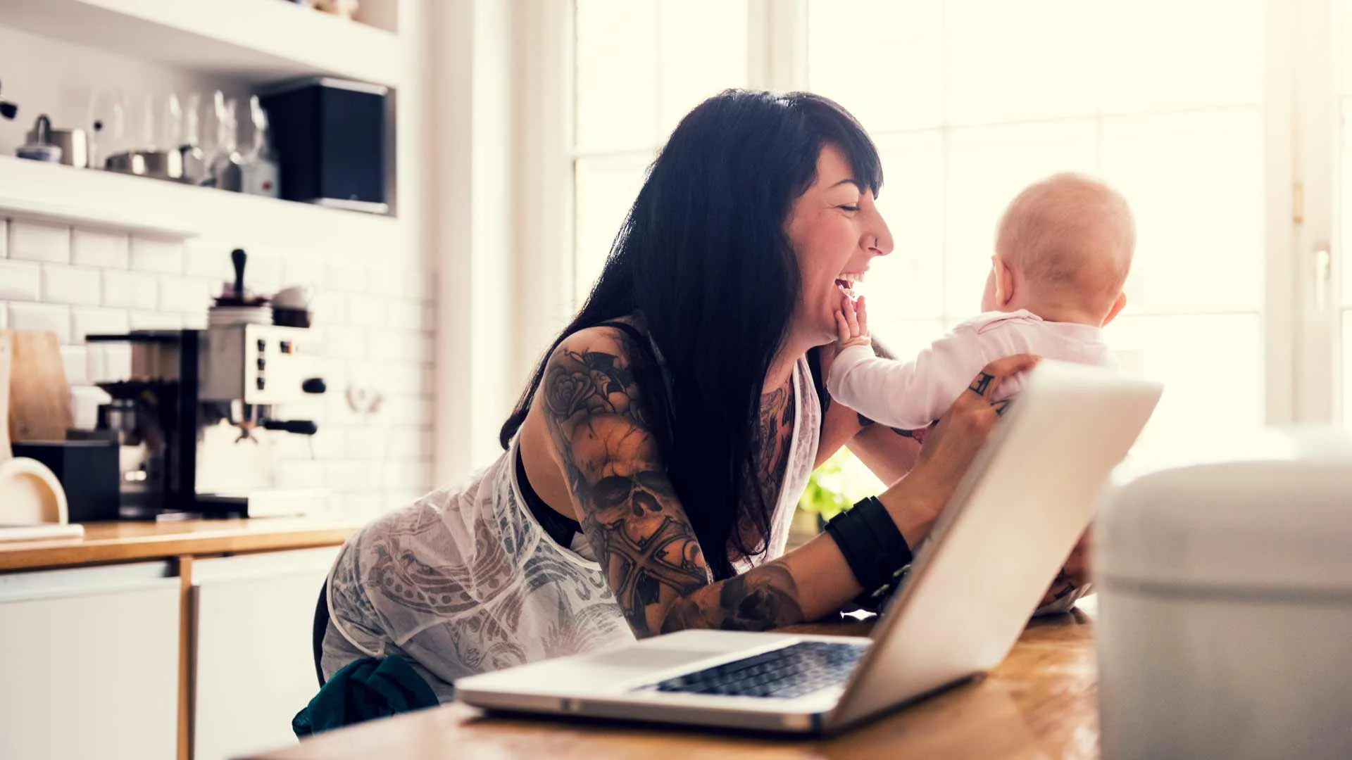 Mother playing with newborn baby at home before returning to work.