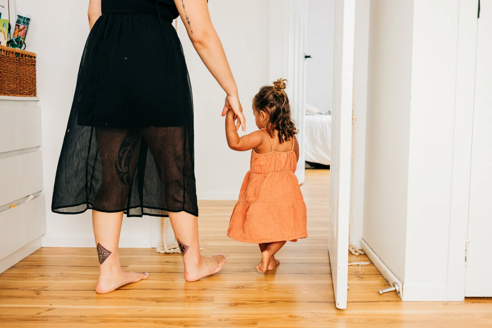 Māmā holds her child's hand