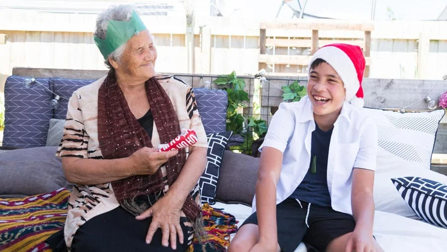 Grandmother and grandson opening a Christmas gift