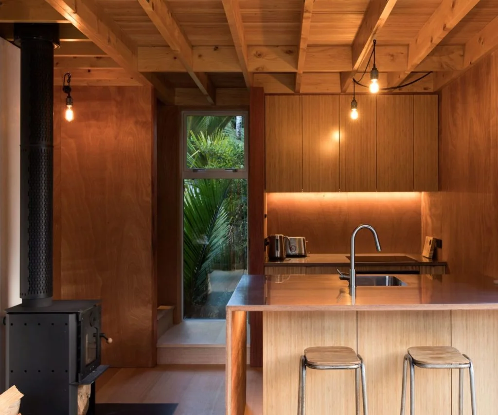 Tiny kitchen with wood fire and two bar stools