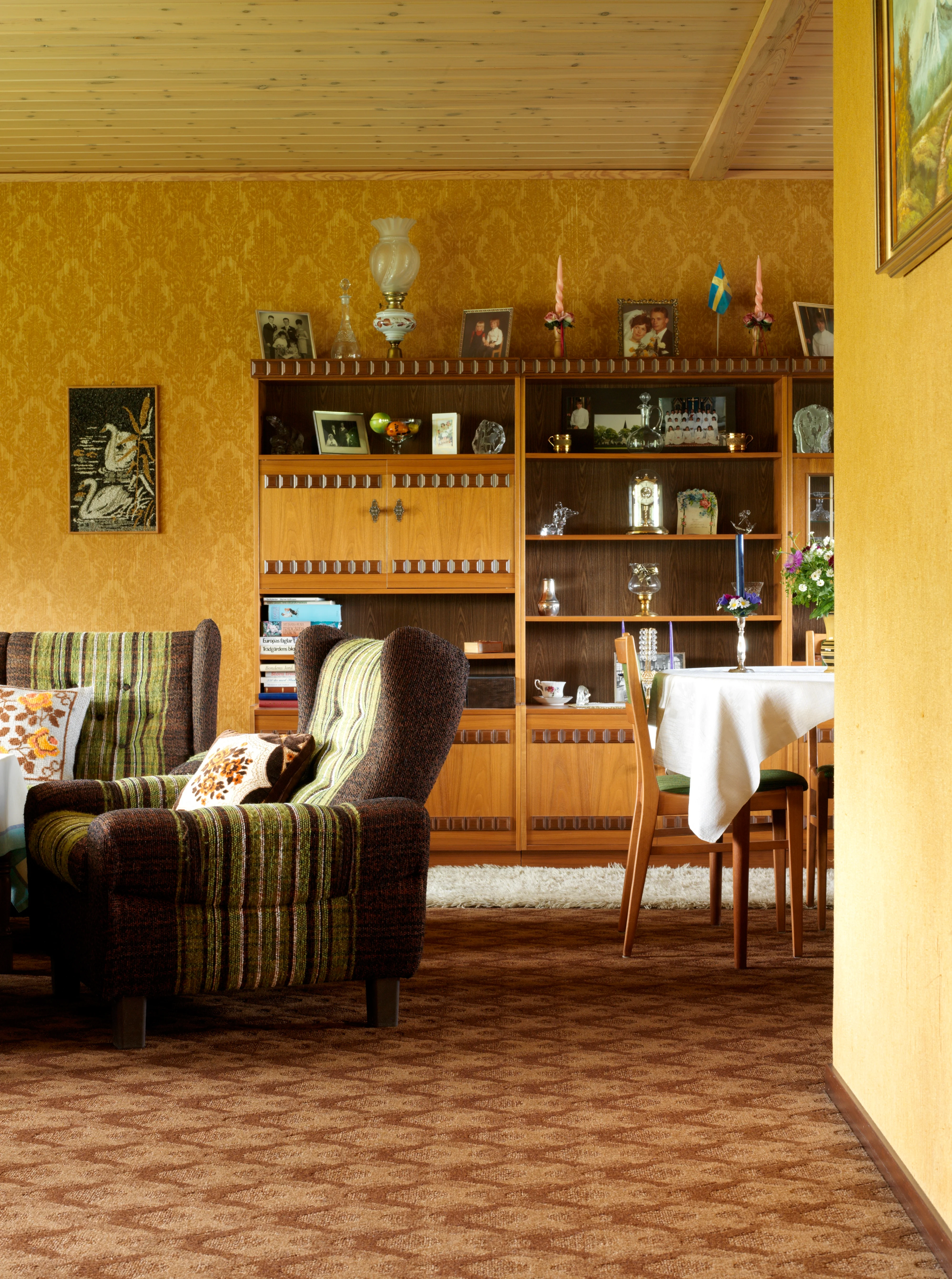 An old fashioned room with retro furniture and patterned carpet.