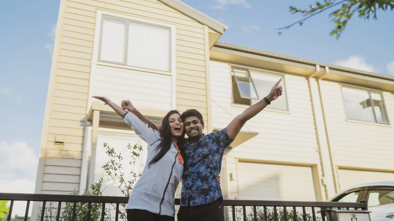 Off the plan apartment buyers. Couple in front of new home.