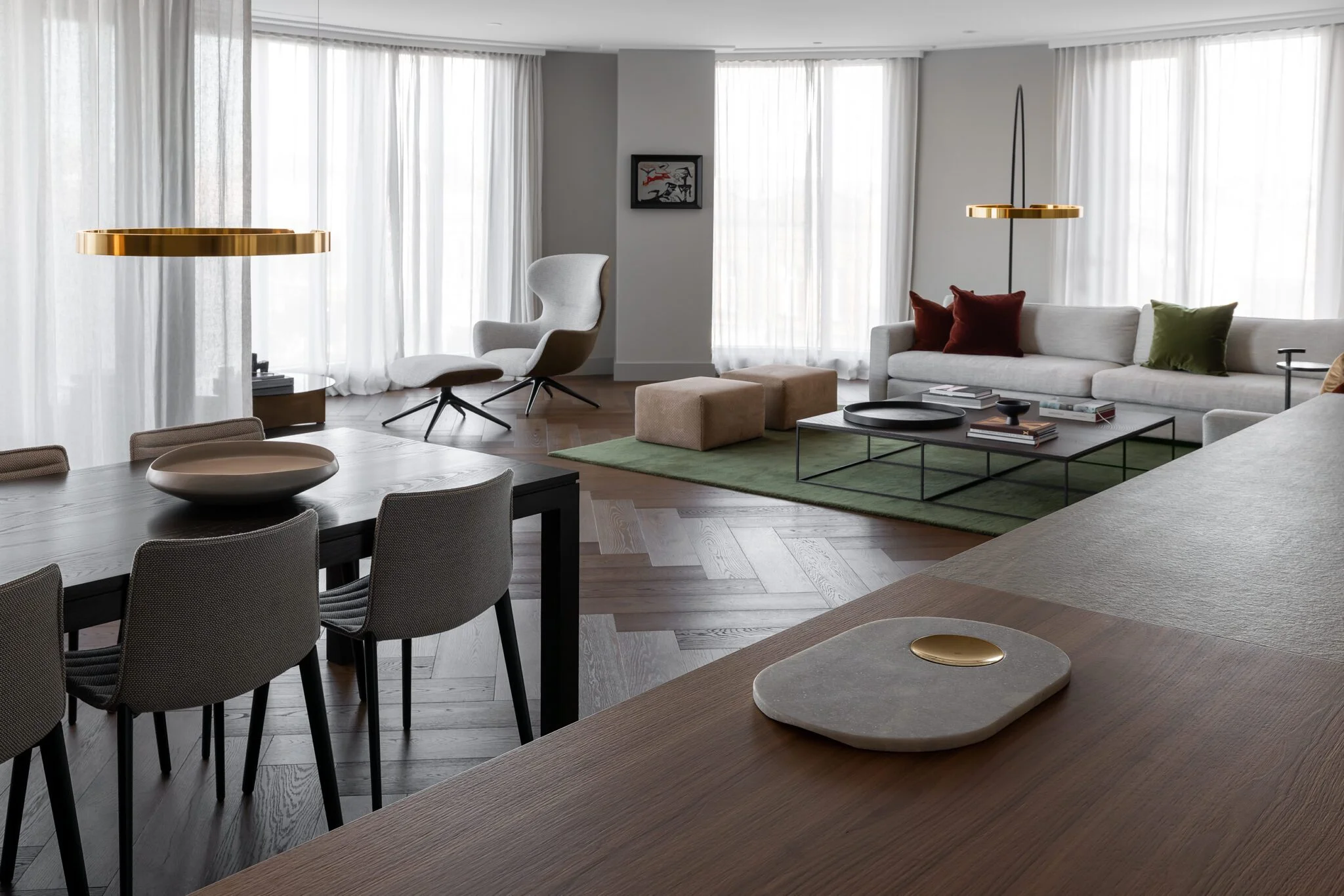 Bright living and dining area with sheer white curtains, modern furnishings, and a soft, neutral colour palette.