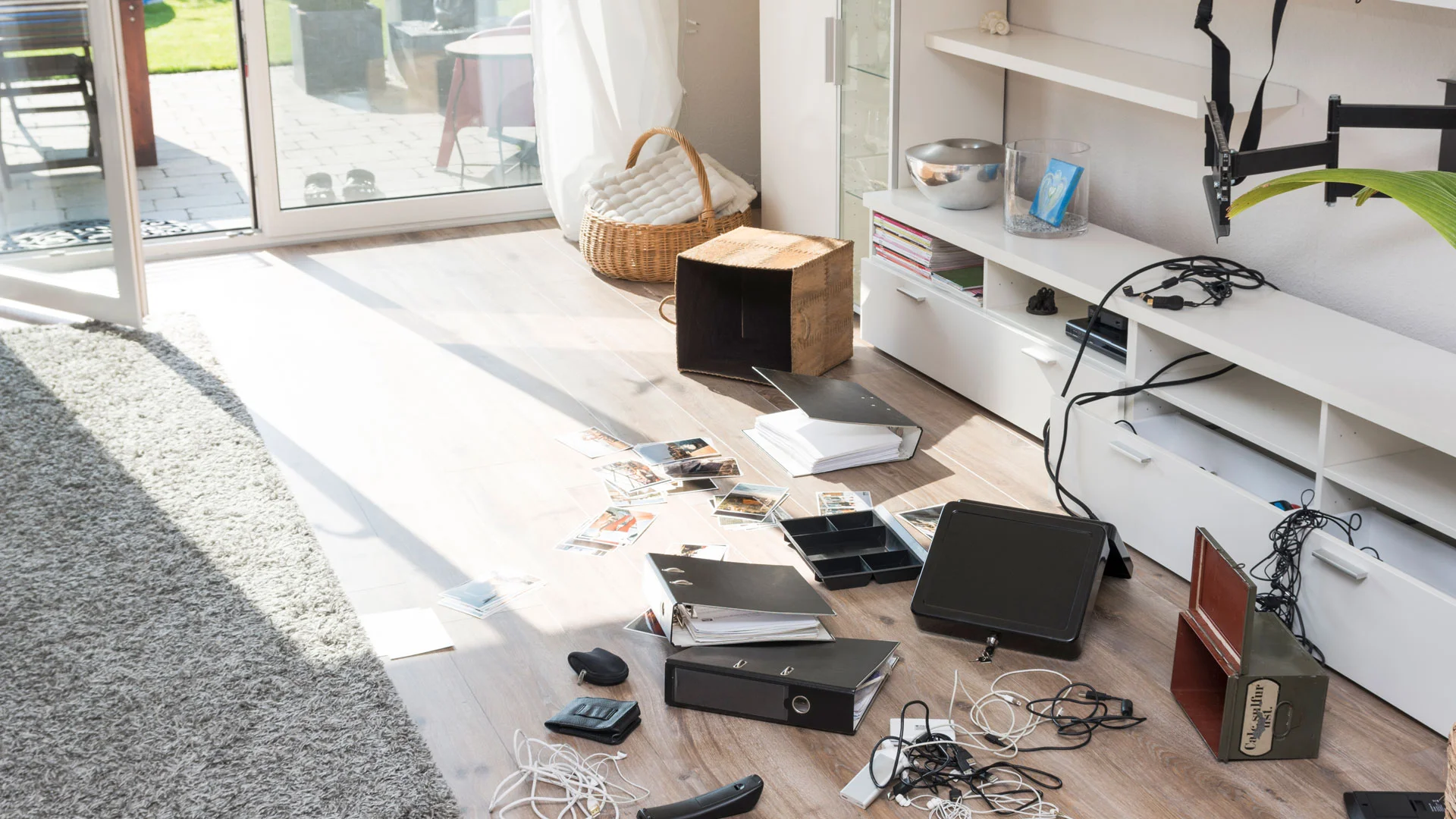 A messy living room of a property in New Zealand, following a burglary.