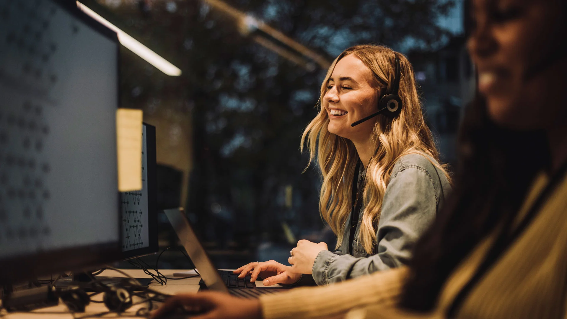 Young female empoyee talking on a headset working in a customer service role.