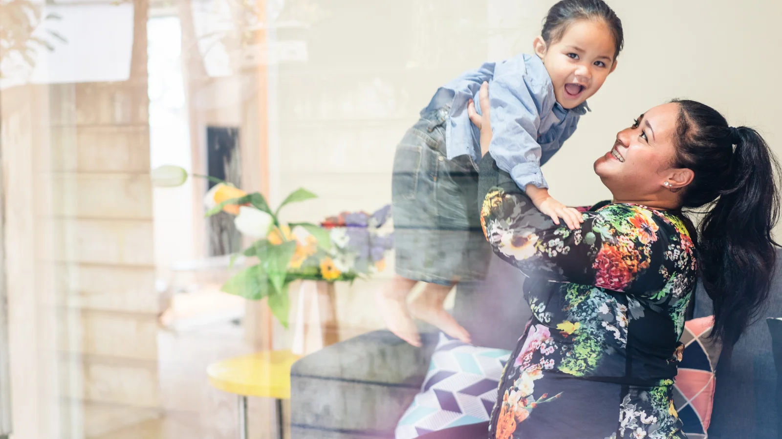 Mum holding up child.