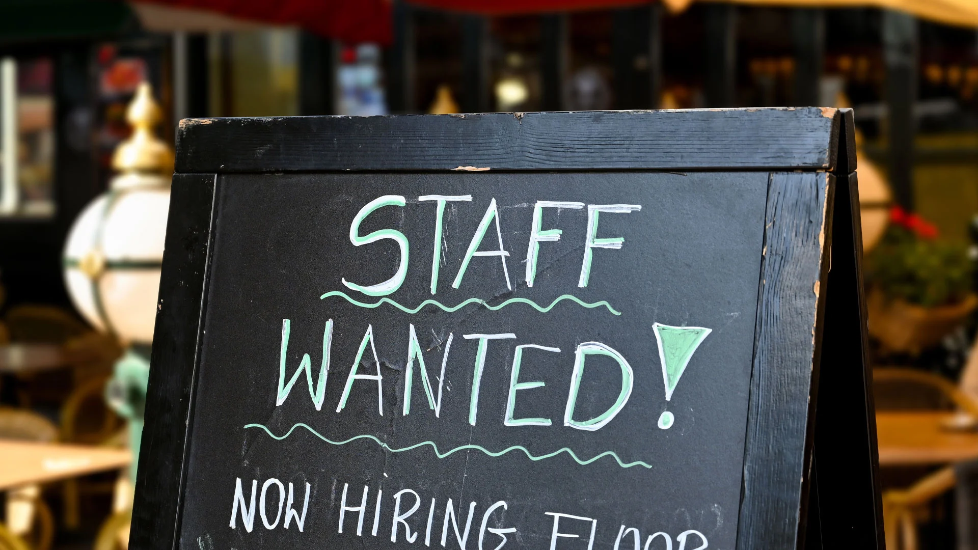 Blackboard outside a restaurant with the words "Staff Wanted!" written on it.
