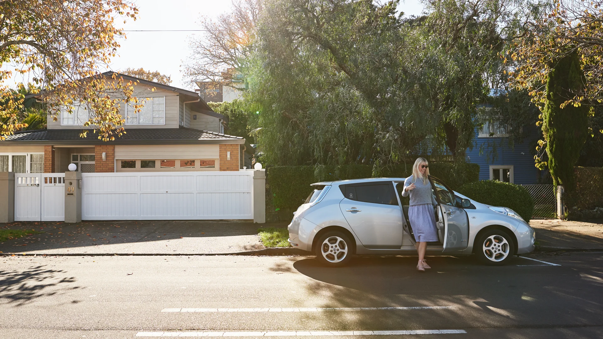 Woman standing next to silver car
