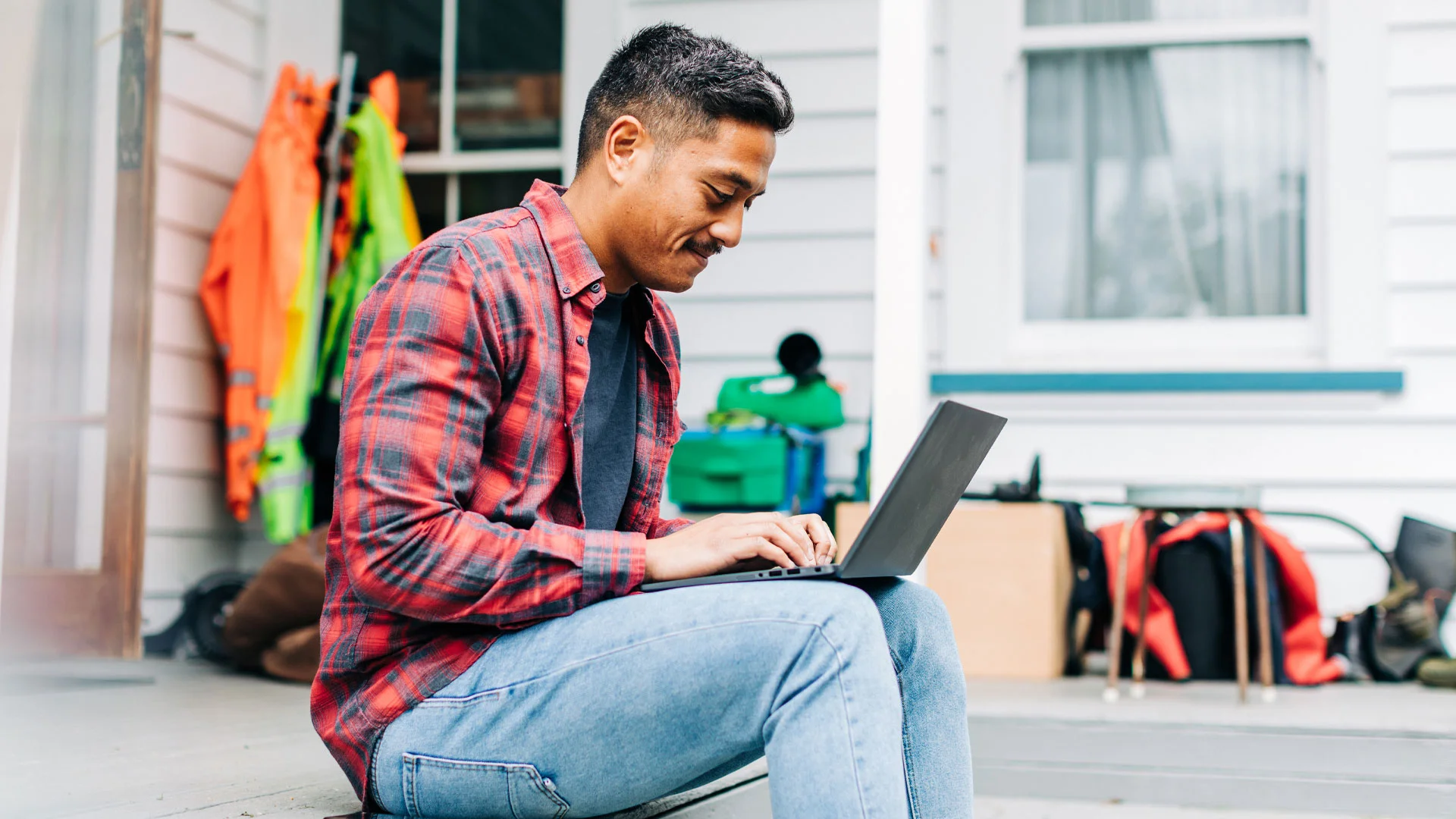Man conducting salary research on a laptop on his deck.