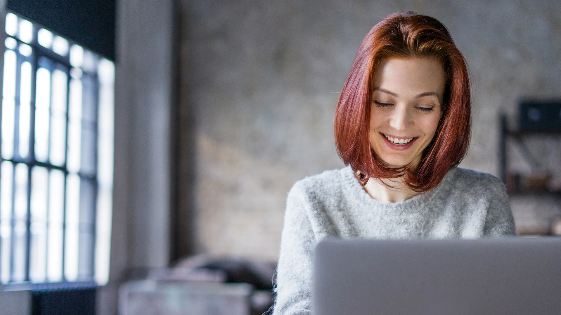 Young female copywriter workong on her laptop in an office.