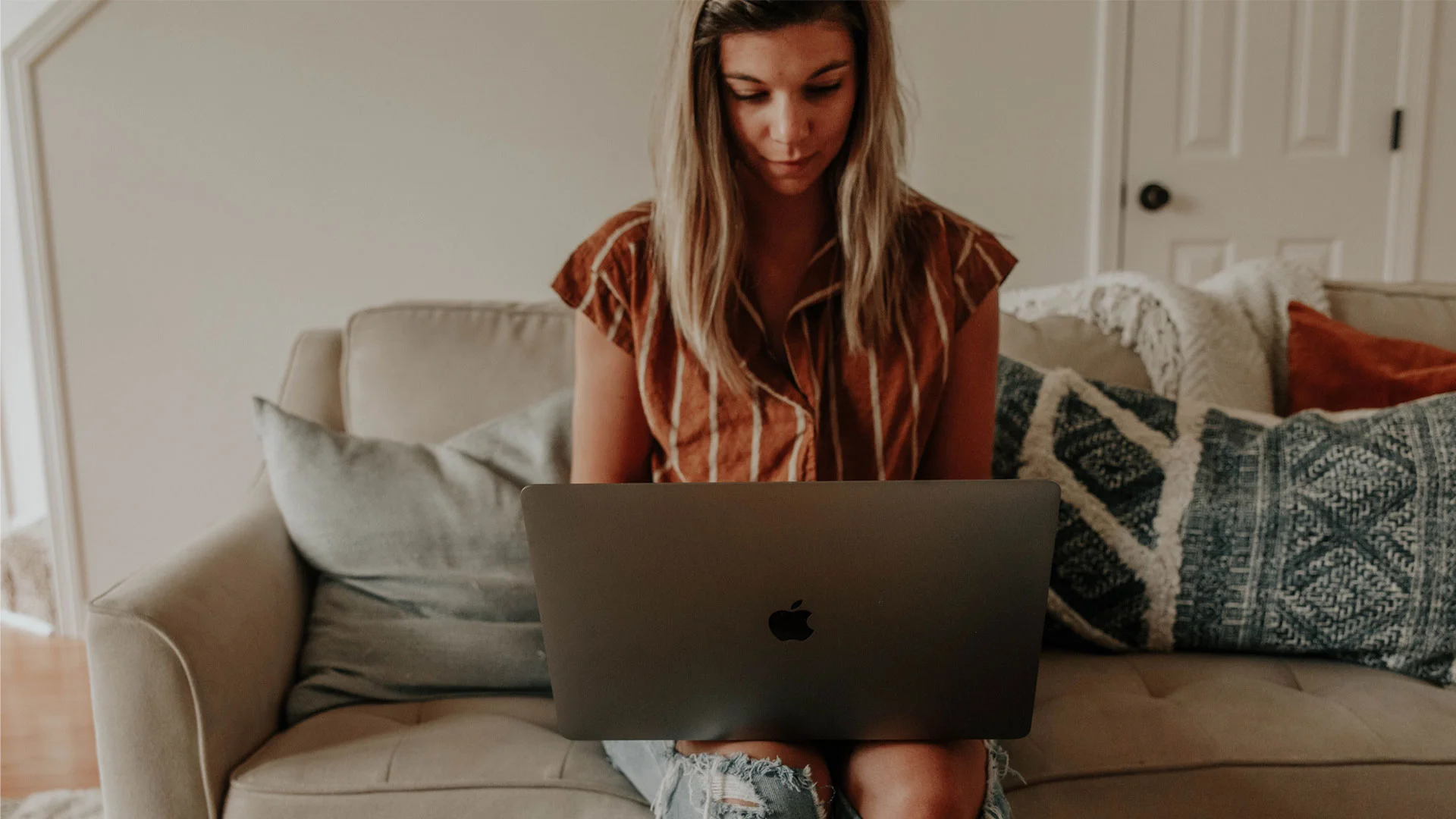 Woman reading documents on her laptop at home.