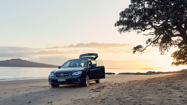 Car parked on beach with doors open
