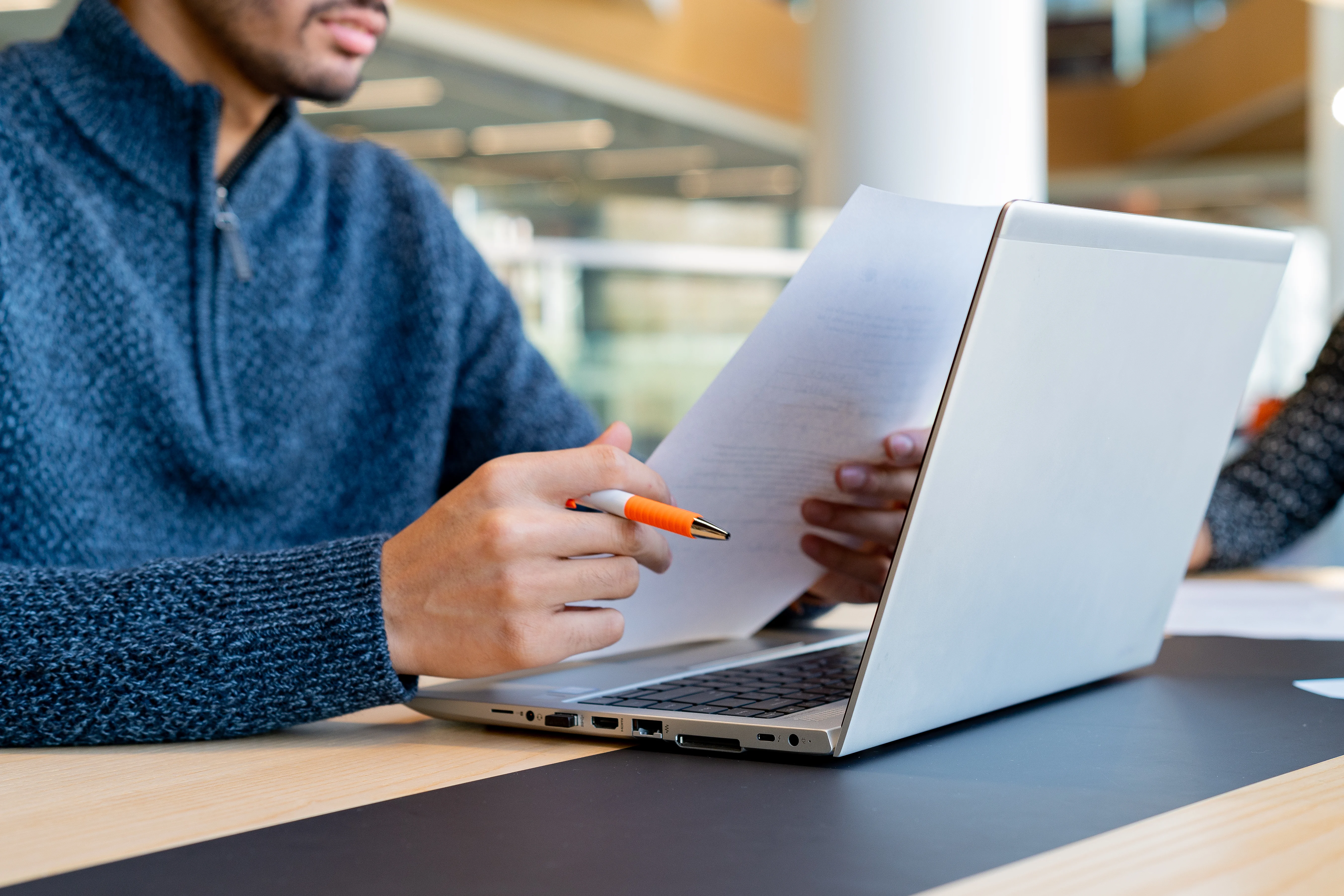 Man at laptop in office reviewing paperwork