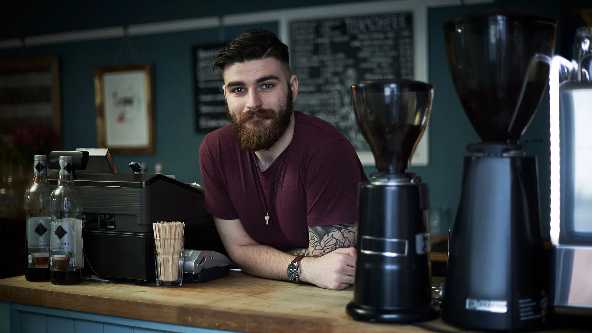 Barista leaning on the counter in a cafe.