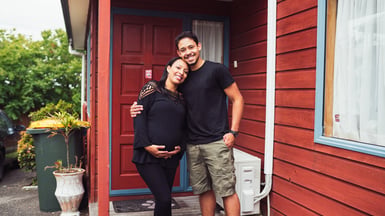 Couple outside their first home in Auckland