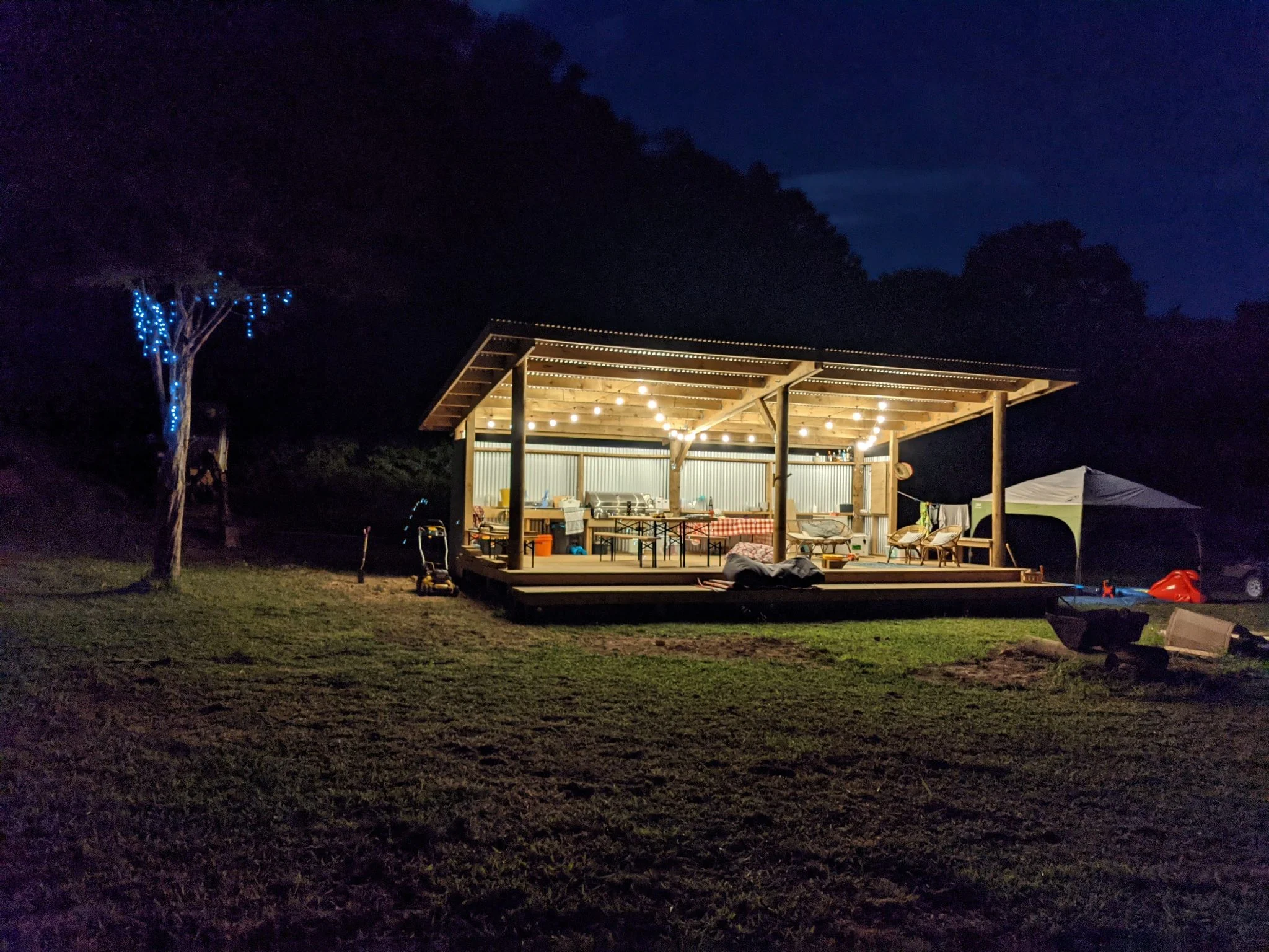 A night time photo of a wooden shack that is lit up. A peaceful oasis