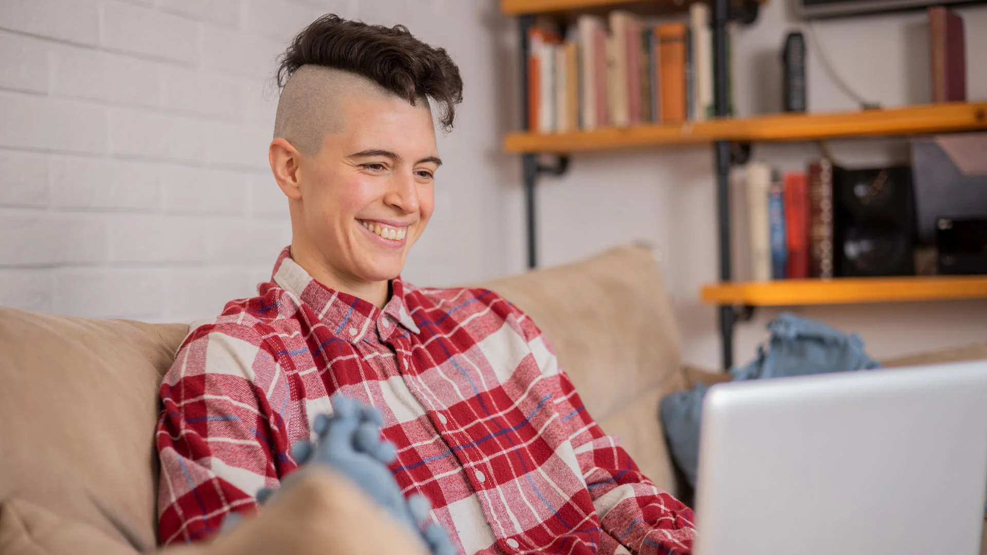 University student writing her CV on a laptop at home.