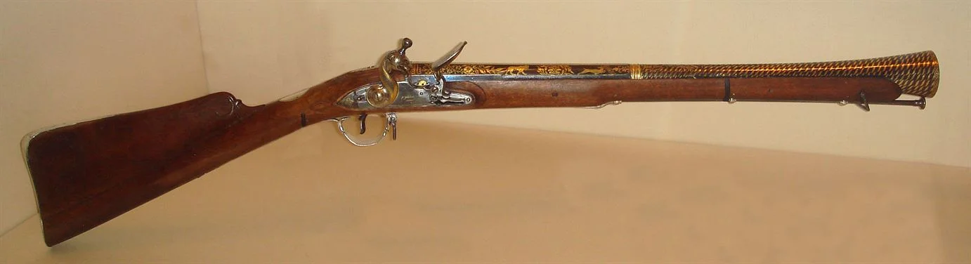 an old wooden blunderbuss firearm with silver and brass filigree patterning