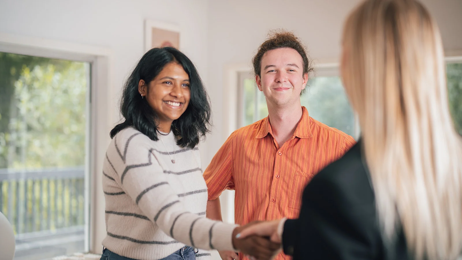 Couple buying an apartment and real estate agent gifts flowers.