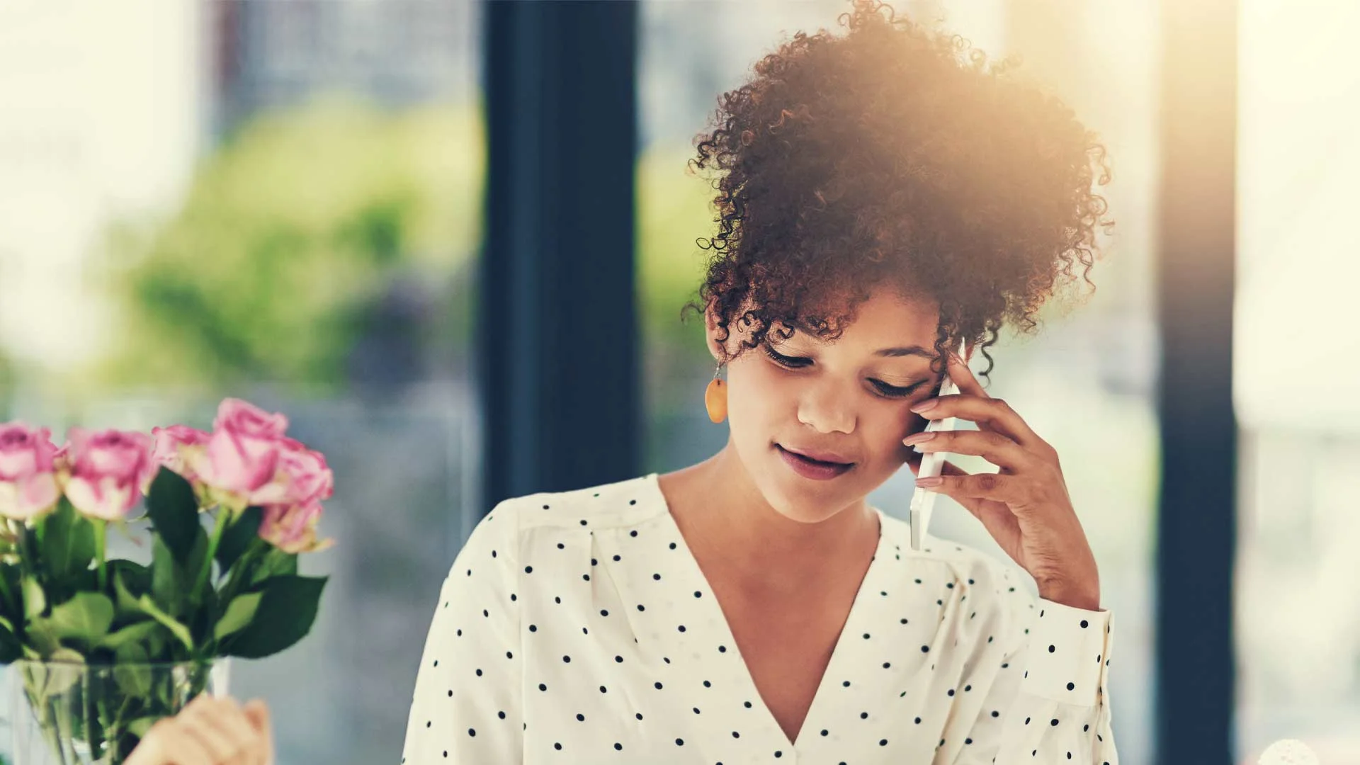 Young candidate looking at her CV while on the phone to a hiring manager.