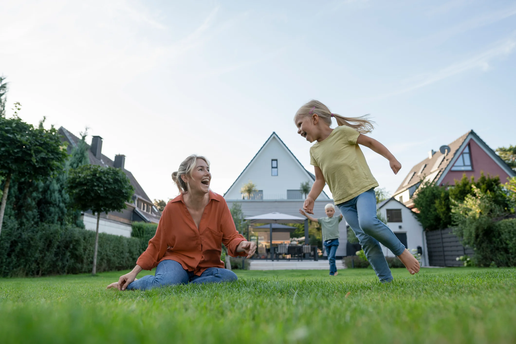 Image of mother and children playing in a backyard.
