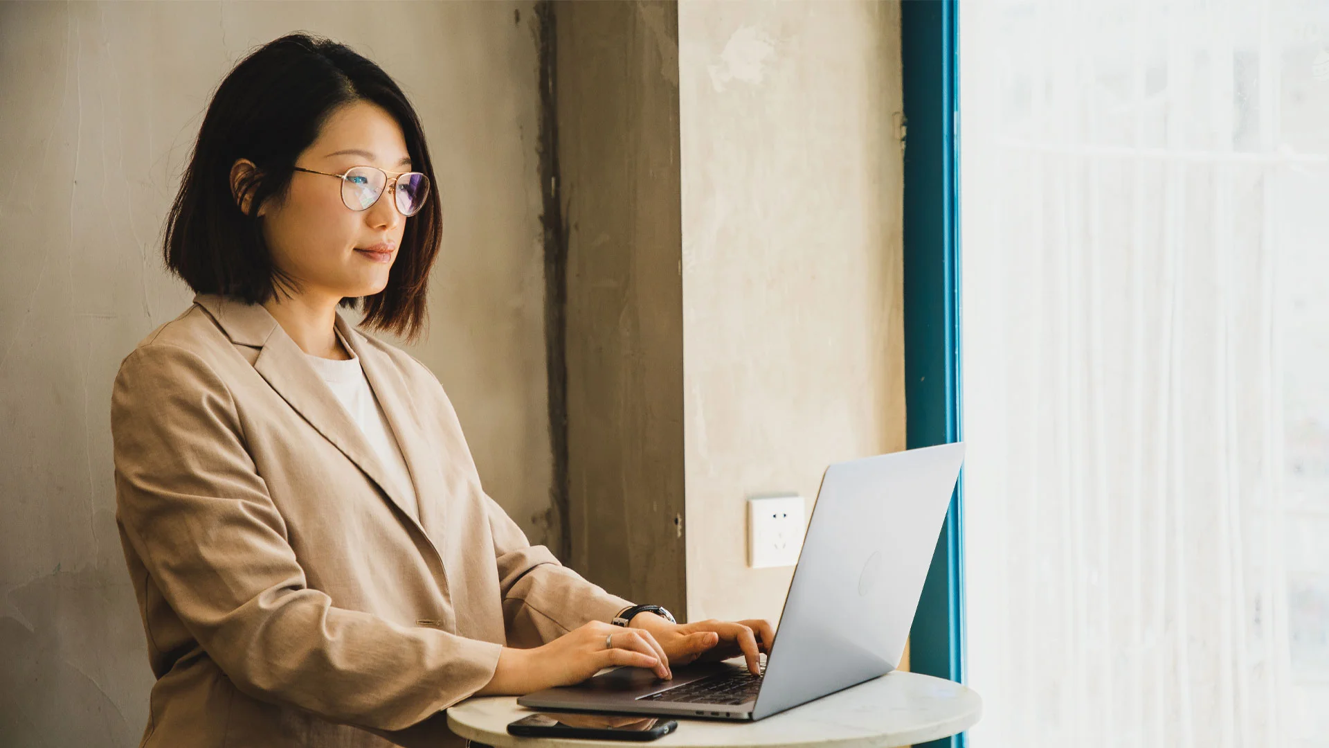 Lady writing a follow up email on her laptop, asking for an update on her job application.