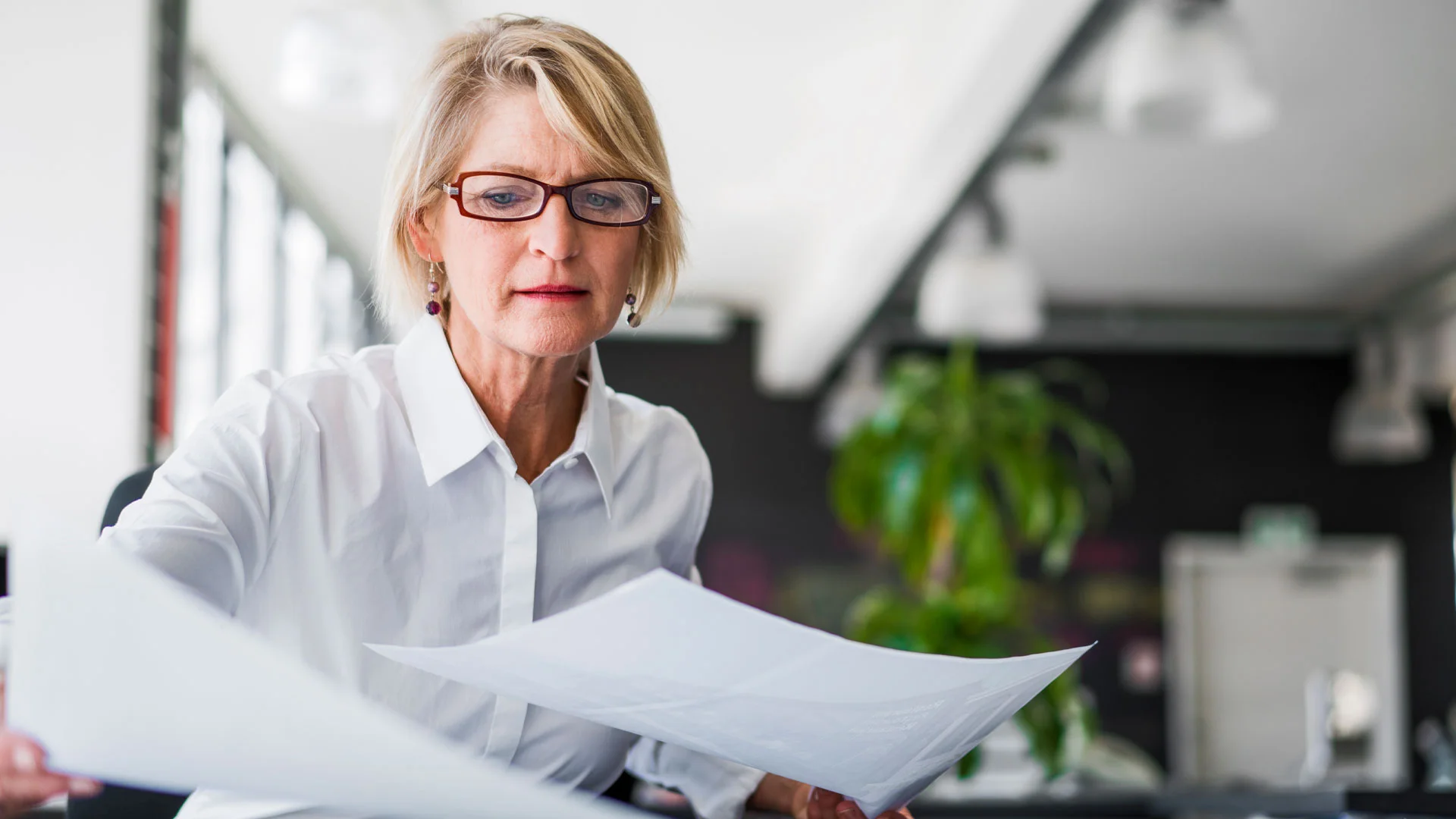 Female policy analyst reviewing papers in her office.