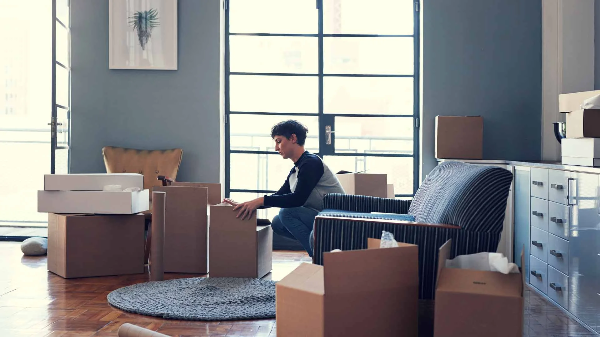 Young woman packing up her possessions at the end of a tenancy.