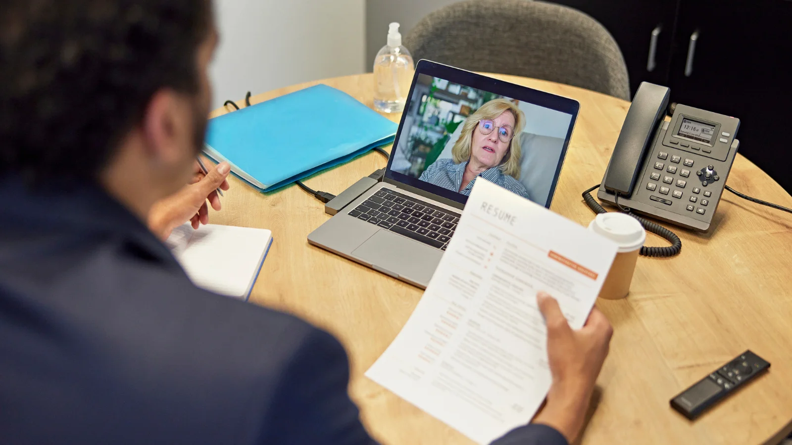 Guy looking at resume while interviewing lady.