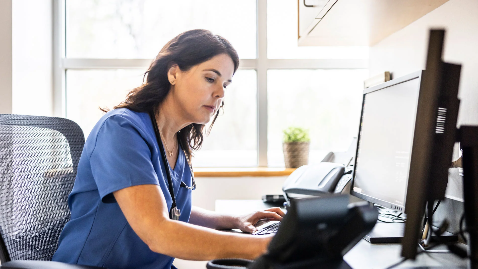 Nurse Practitioner working on a laptop in her office.
