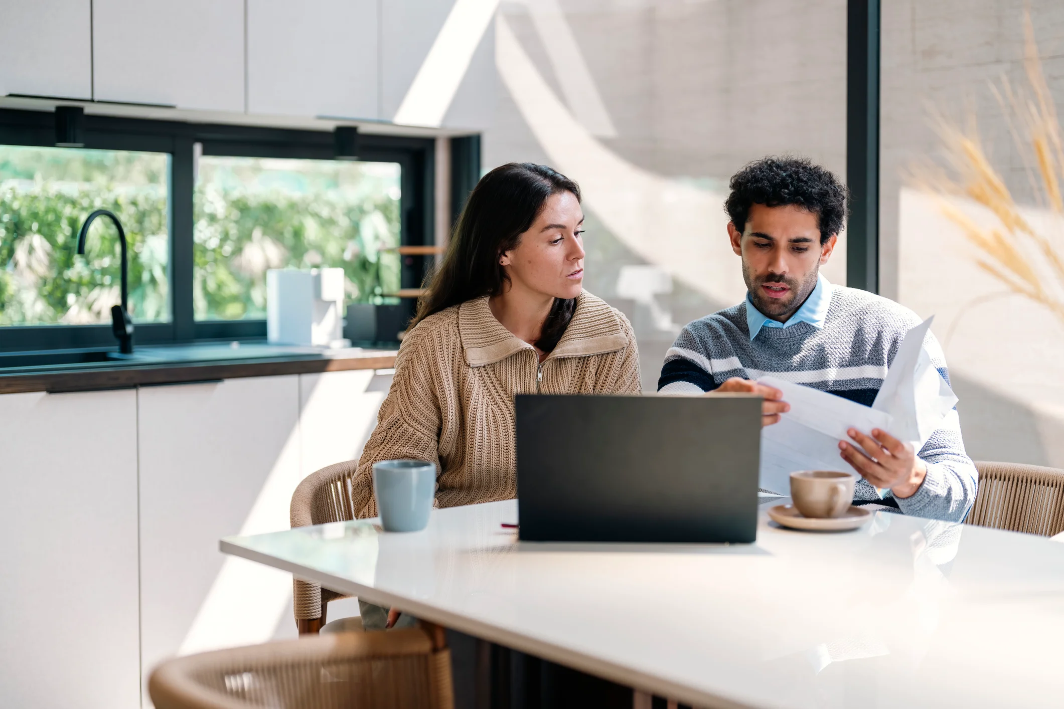 A couple reviewing documents together at home, discussing how to divide assets after separation in New Zealand.