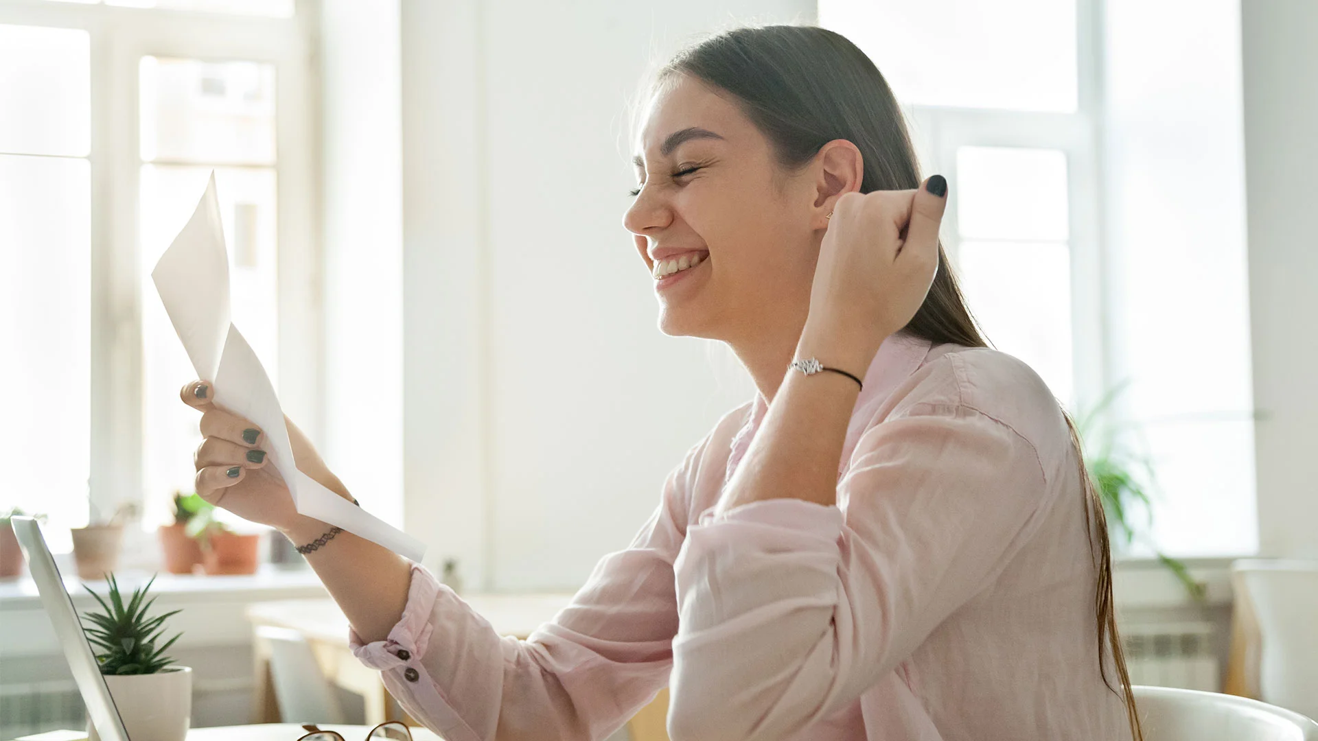 Woman reading a job offer letter and celebrating