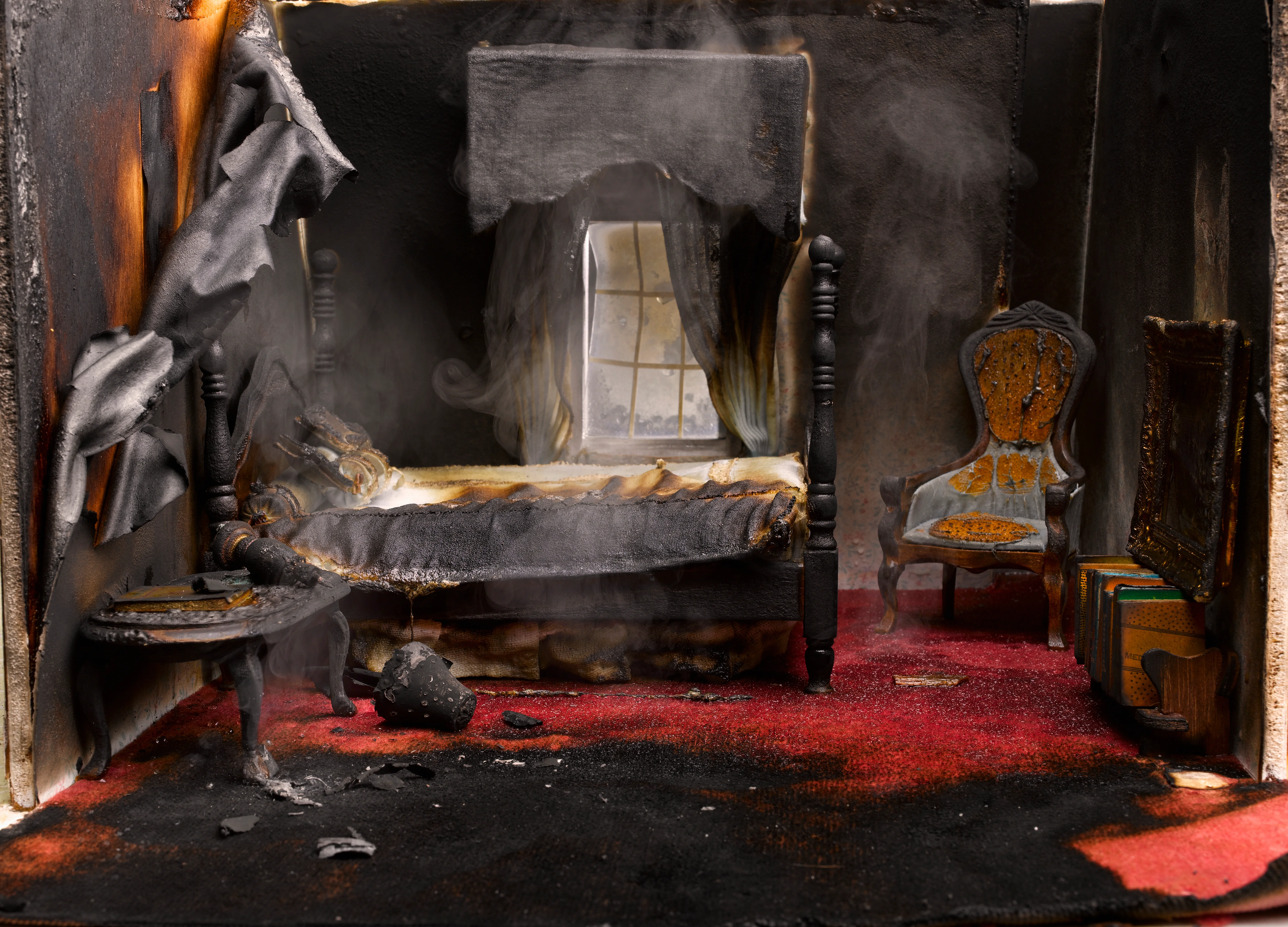 Scale model of a bedroom after a fire