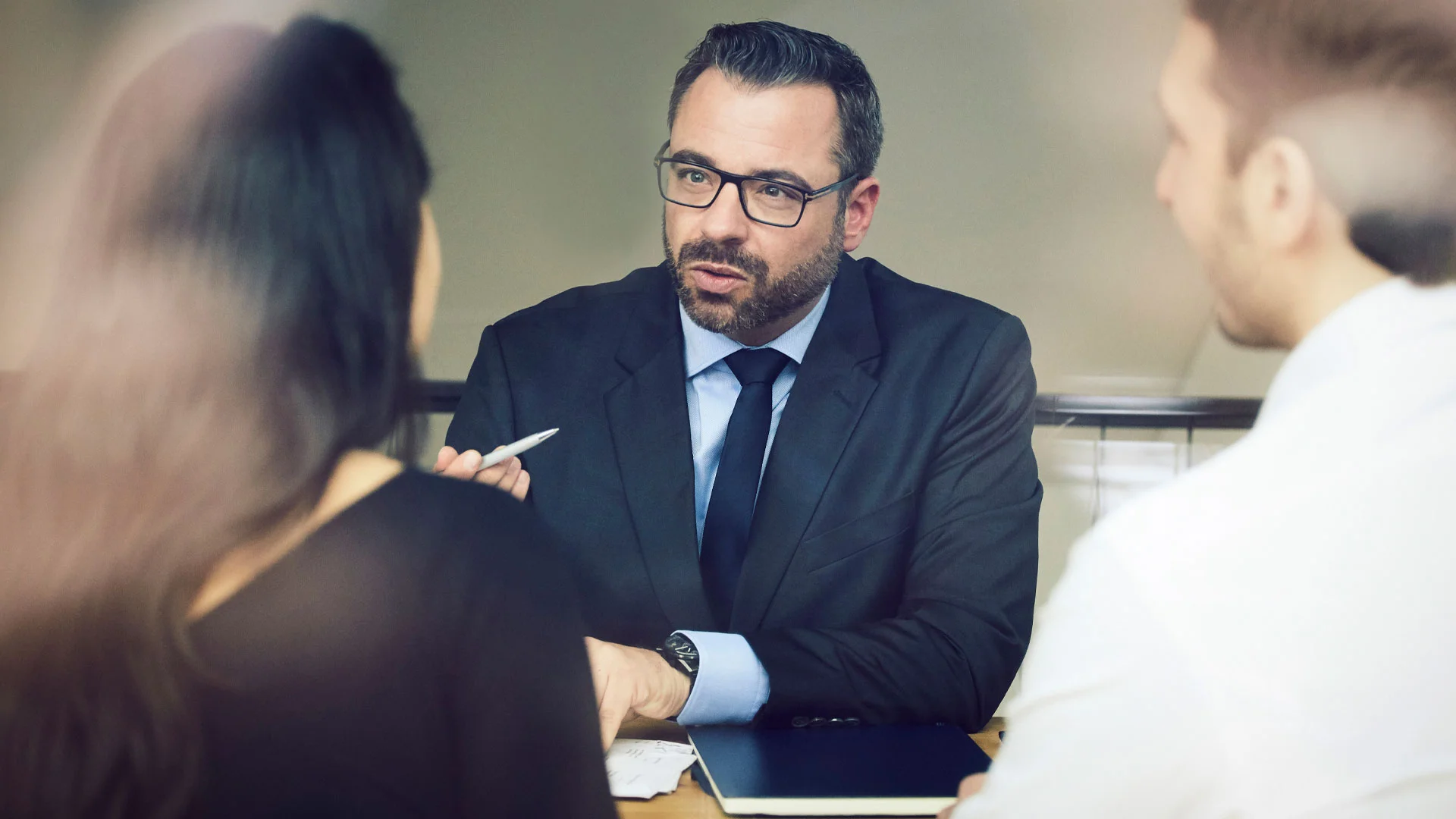 Smartly dressed male law job interview candidate answering questions.