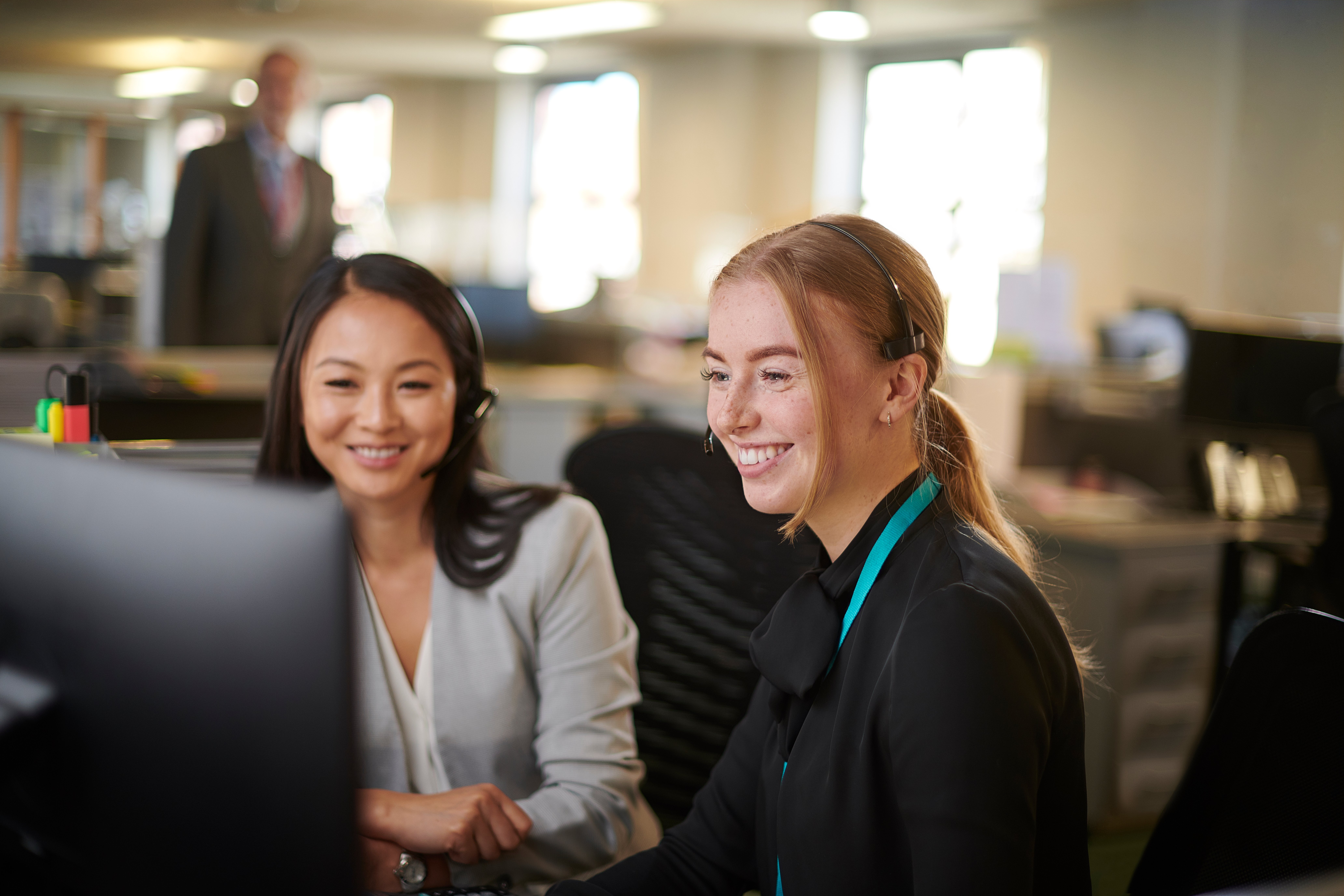 2 women sitting at a computer