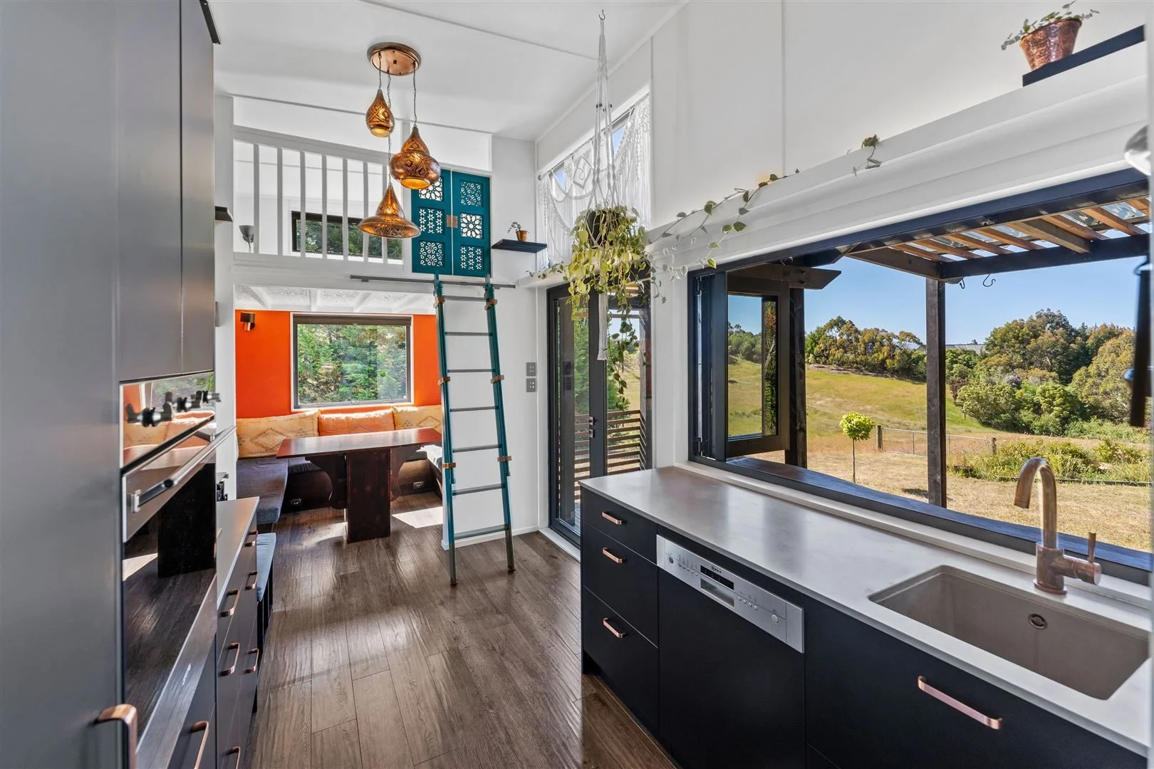 Kitchen, dining and ladder to bedroom in a container home